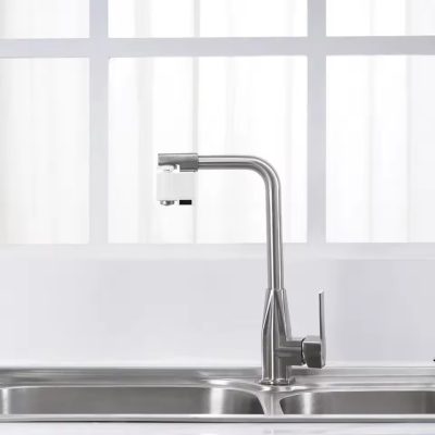شیر آب کم‌مصرف اتوماتیک مدل HD ZNJSQ 02 نصب‌شده روی شیر ظرفشویی استیل با طراحی مدرن، مناسب برای خروجی آب بدون تماس و صرفه‌جویی در مصرف آب در آشپزخانه